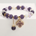 Detailed macro of purple crystal beaded bracelet with a clover-shaped gold pendant - Four-Leaf Clover