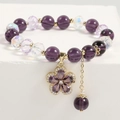 Detail of purple crystal star bracelet with gold floral pendant and faceted beads - Petal Style