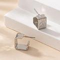 Minimalistische silberne Hammerschlag-Ohrstecker auf einer weißen geometrischen Plattform - Silber