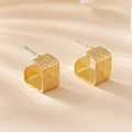 Detailansicht goldener quadratischer Creolen mit Hammerschlag-Textur unter Schatten - Gold