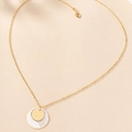 Close-up of golden chain necklace with layered shell and polished disc pendants - Gold
