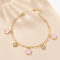 Detail of gold chain anklet featuring pink flower charms and textured golden hearts - Pink Flower Style