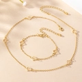 Dettaglio del set collana e bracciale dorato con quadrifogli traforati e chiusure - Oro