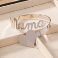 Polished silver mama heart arm cuff bracelet on beige jewelry tray display - Silver