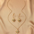 Detalle de un conjunto de joyas vintage doradas con cuentas de turquesa sobre seda fina - Dorado