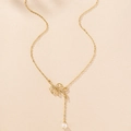 Détail du collier doré avec pendentif feuille d'olivier évidée et perle blanche élégante - Doré
