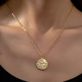 Elegante goldene Münz-Halskette mit geprägtem Kreuzmuster an einer feinen Kette - Gold