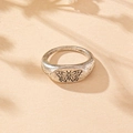 Macro detail of vintage silver butterfly signet ring with soft shadow on beige paper - Silver