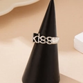 Fashion silver 'KISS' letter ring in punk vintage style displayed on a black conical stand - Silver