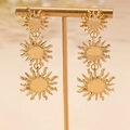Vintage gouden drievoudige zon oorbellen met gehamerde textuur op een elegante metalen standaard - Goud