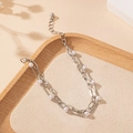 Detail of double-layer silver chain bracelet with white pearls on a minimalist tray - White Gold