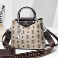 Close-up of the beige handbag with letter prints, silver handle, and star pendant - Beige/Coffee Letter Print Style (Style 7)