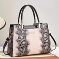 Detalle del bolso con estampado de lagarto en rosa y marrón con accesorios metálicos dorados - Rosa