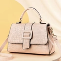 Detail of lizard embossed pattern and gold hardware on beige crossbody tote bag - Khaki