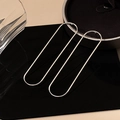 Minimalist silver geometric oval outline earrings with sleek metallic finish on black base - Silver