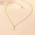 Close-up of pink flower pendant on a gold chain with detailed enamel and clasp - Pink