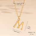 Detail view of gold letter M pendant with bamboo texture and 45+7cm chain measurements - M