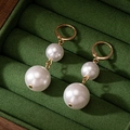 Elegante gouden dubbele pareloorbellen op een donkergroene fluwelen sieradendoosje - Wit