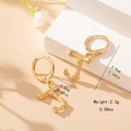 Detail view of gold bamboo alphabet earrings on a pedestal with size dimensions - Letter J Style