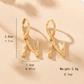Macro detail of golden letter N earrings with bamboo texture and product dimensions - Letter N Style