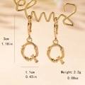 Detailed view of letter Q bamboo texture gold dangle earrings with dimension markers - Letter Q Style