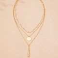 Dettaglio della collana a tre strati dorata con perle e pendenti a disco e barra - Oro