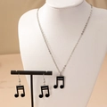 Detailed view of silver note jewelry set with black enamel inlay on elegant display stands - Black Double Note 2-Piece Set