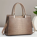 Detail view of brown crocodile texture shoulder bag with gold hardware and top handles - Khaki