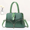 Detailed view of dark green crocodile texture handbag with decorative V-shaped zippers - Green
