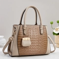 Elegante beige Handtasche mit Krokodilprägung, Goldbeschlägen und Mini-Charm-Anhänger - Khaki