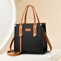 Chic black faux leather tote bag with brown contrast straps and stylish tassel accents - Black