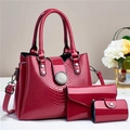 Detail view of the glossy red faux leather textures and metal hardware of the 3-piece bag set - Rose Red