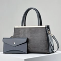 Detail of dark blue crocodile texture handbag and glossy clutch with gold metal accents - Gray