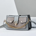 Détail d'un sac gris à motif lézard avec un fermoir rotatif doré en forme de G chic - Gris