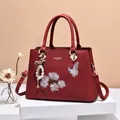 Elegant deep red leather handbag with floral embroidery, pearl charms and tassel detail - Burgundy / 31x13x22cm