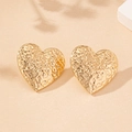 Detailed view of golden heart stud earrings with elegant hammered textured finish - Gold