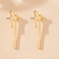 Macro shot of minimalist gold vertical melting heart earrings on beige textured card - Gold Long Heart