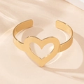 Detail shot of a minimalist gold hollow heart open bangle with high polished finish - Gold