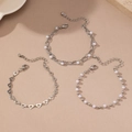 Detailed view of silver heart hollow bracelets and white pearl jewelry set on stone base - Silver 3-Piece Set