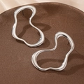 Minimalist silver hollow heart line earrings with polished finish on a textured display - Silver