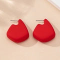 Close-up of red matte geometric fan earrings with minimalist 3D artistic design - Red