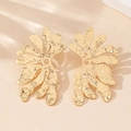 Détail macro de boucles d'oreilles fleur dorées avec texture métal martelé et pétales - Jaune d'Or