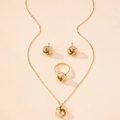 Gedetailleerde weergave van gouden sieradenset met ketting, oorknopjes en knoopring - Twist Knoop Stijl / Gouden 3-Delige Set