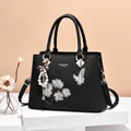 Elegant black leather handbag with floral embroidery and pearl butterfly charm - Black / 31x13x22cm