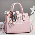 Detail van roze handtas met reliëfstructuur, decoratieve zijden sjaal en klavertje sluiting - Roze