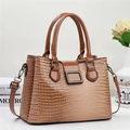 Détail du sac à main marron à motif lézard avec fermoir métallique et anses lisses - Kaki