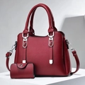 Close-up of wine red pebble leather handbag set with silver hardware and shoulder strap - Wine Red
