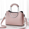 Détail d'un sac à main en cuir rose clair avec poignée métallique demi-ronde et logo - Rose Clair