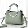 Détail du sac à main en cuir vert clair avec poignée incurvée et chaîne en argent - vert clair