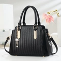 Borsa a mano nera intrecciata con dettagli dorati e ciondolo a fiore decorativo - Nero